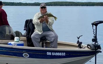 Happy Fisherman In Boat Holding Up Walleye Catch
